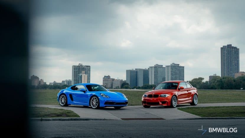 BMW 1M Coupé in Valencia Orange and Porsche 718 Cayman GTS 4.0 in Shark Blue park next to each other and underline their distinctive design and color contrast.